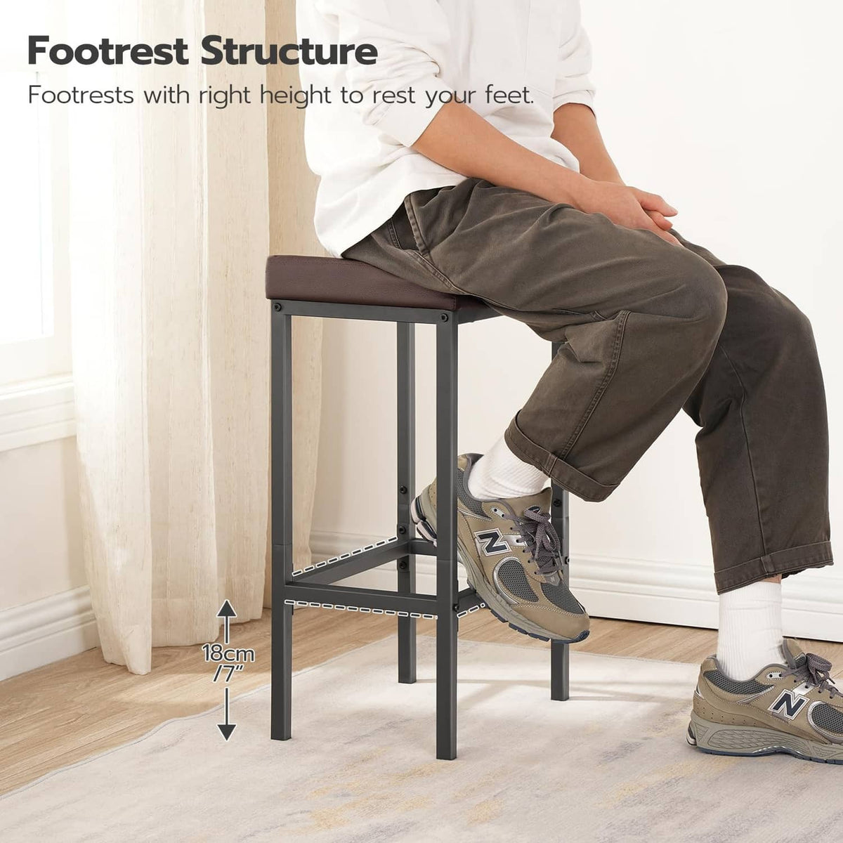 Bar stool with dark brown padded seat and black frame, person seated.