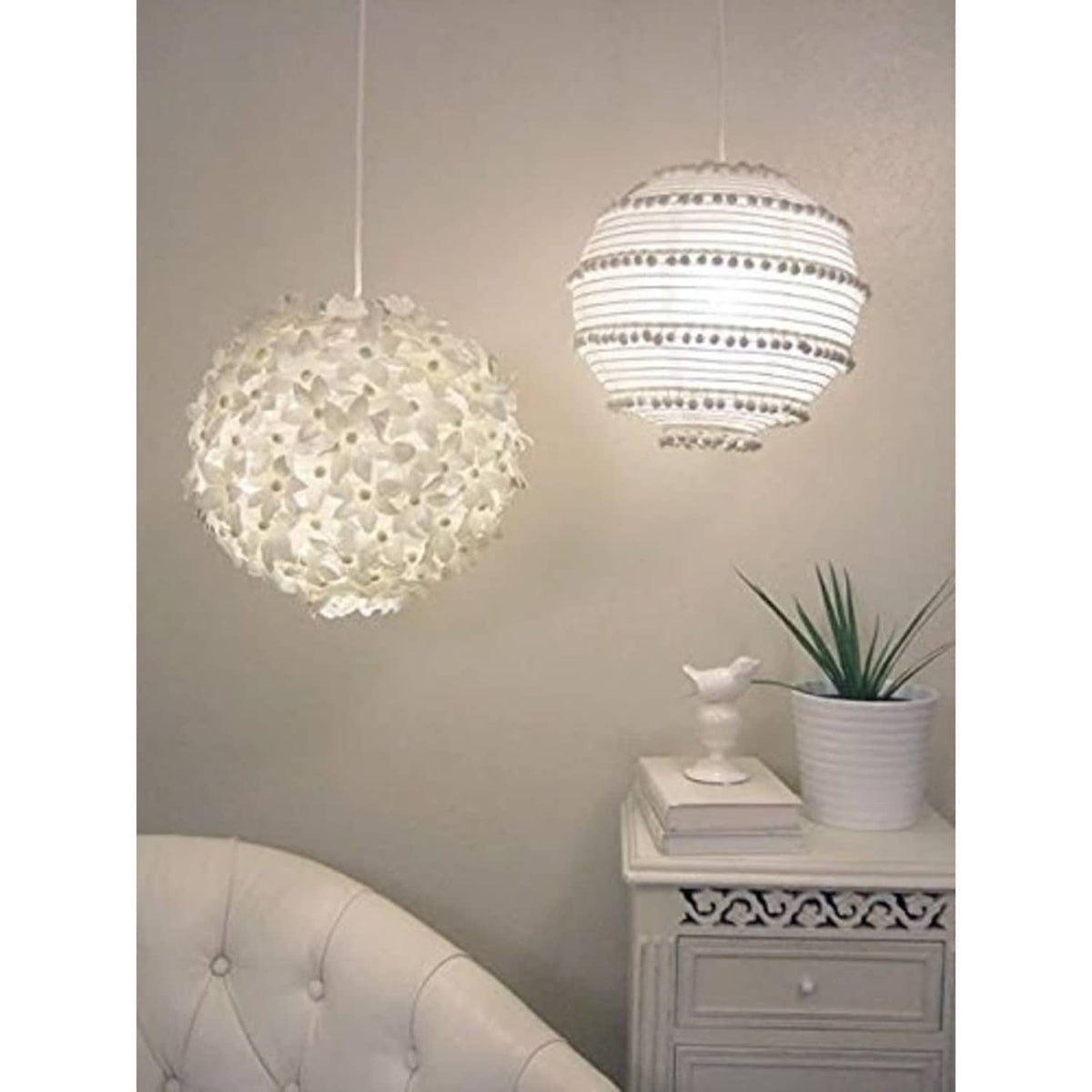 White round paper hanging lanterns, one textured and one striped, suspended from ceiling