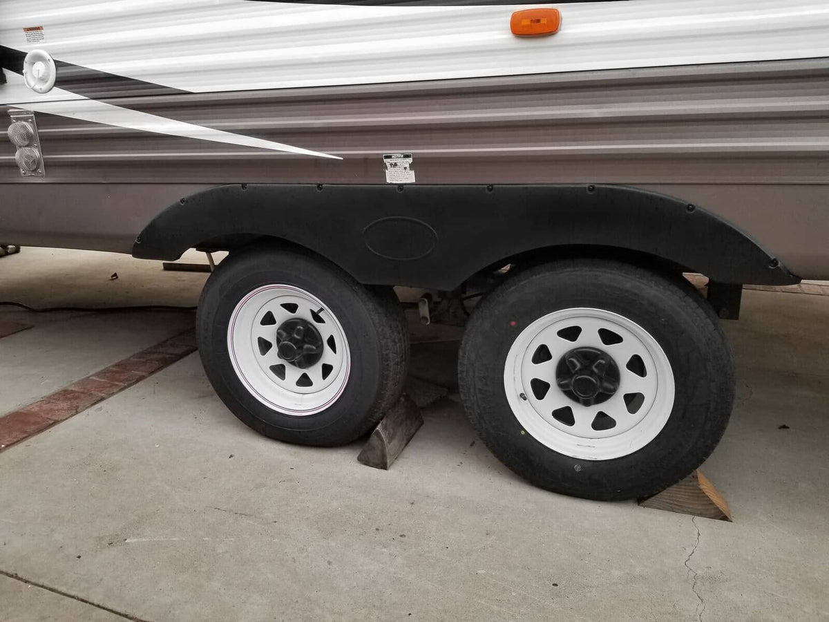 Black RV trailer fender skirt pair with wheel cutouts, curved fit.