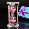 Heart-shaped pink sand hourglass with clear glass frame and sparkling gold accents