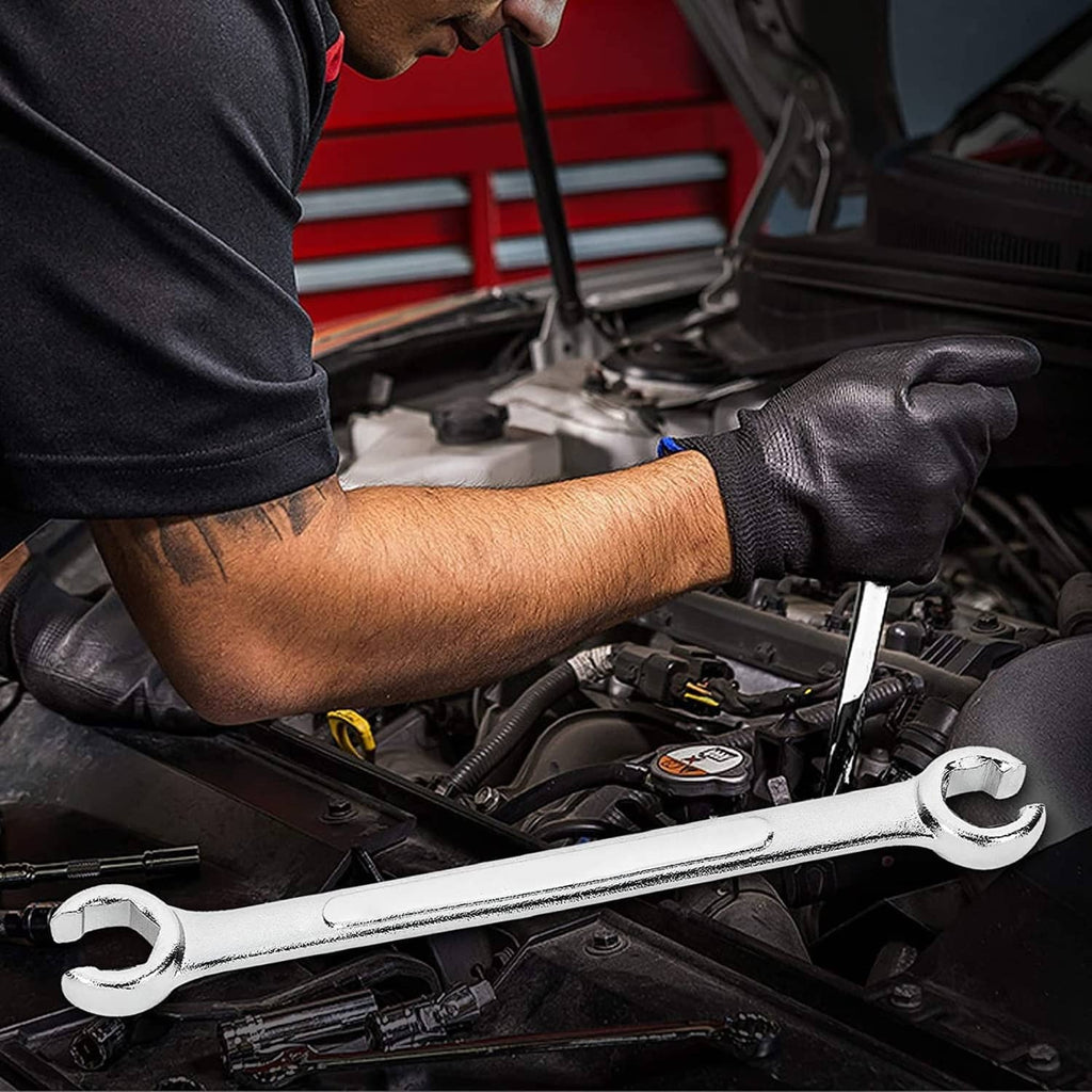 Mechanic holding a flare-nut wrench in an engine bay; gloved grip on the tool.