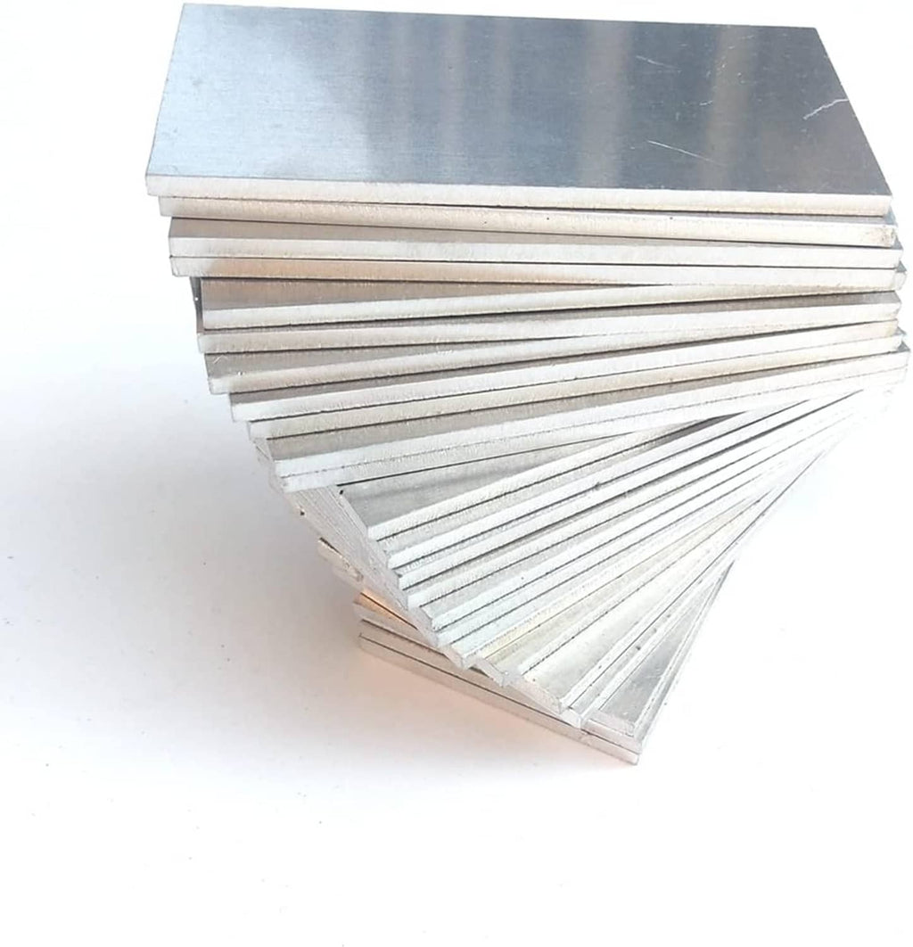Stack of silver aluminum practice coupon sheets, rectangular plates with brushed finish.