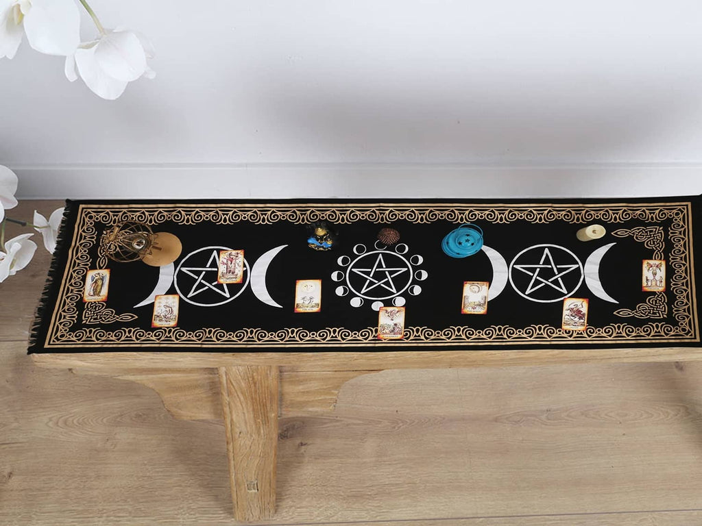 Black altar cloth with gold border and moon/pentagram symbols on tabletop