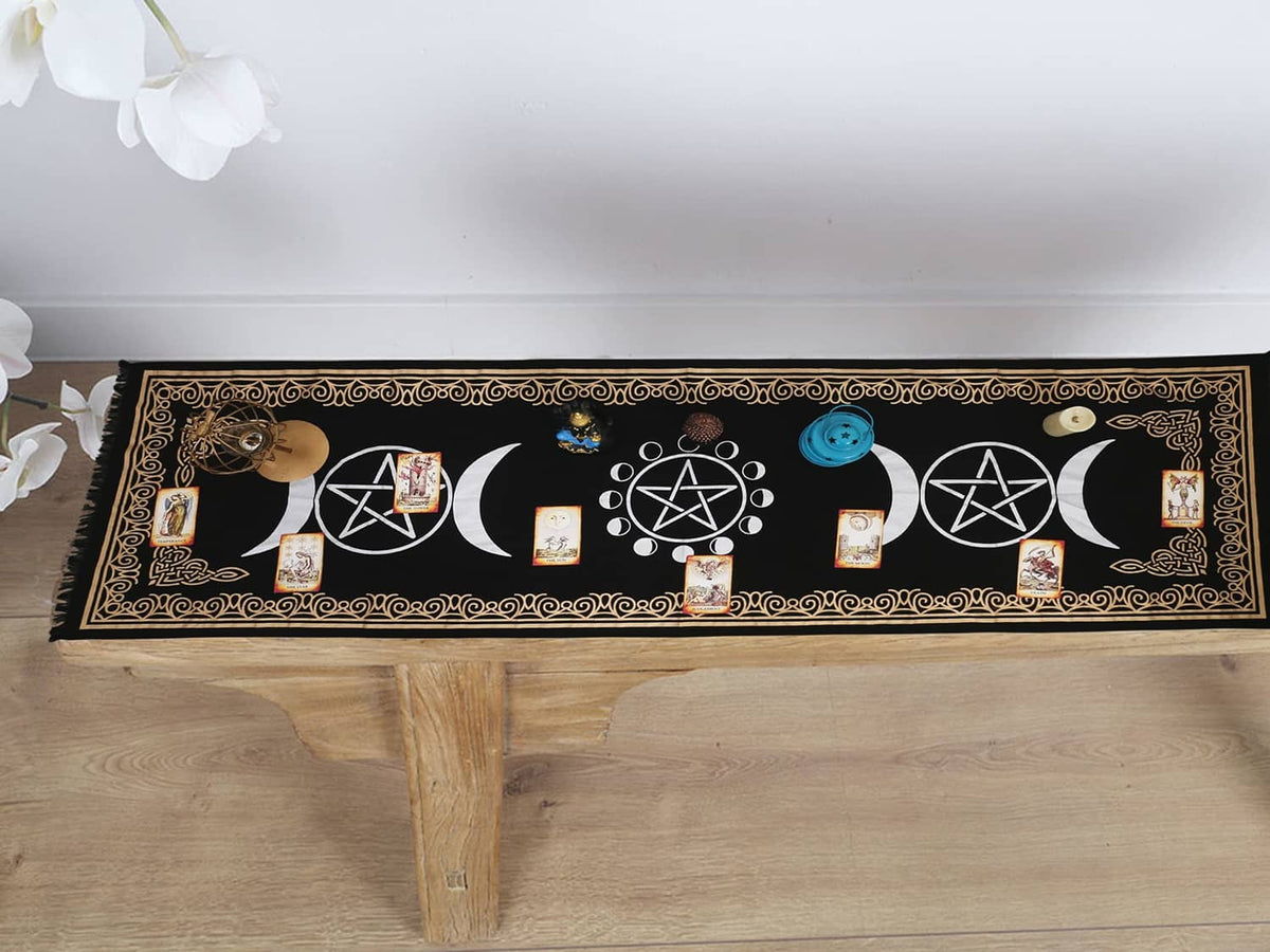 Black altar cloth with gold border and moon/pentagram symbols on tabletop