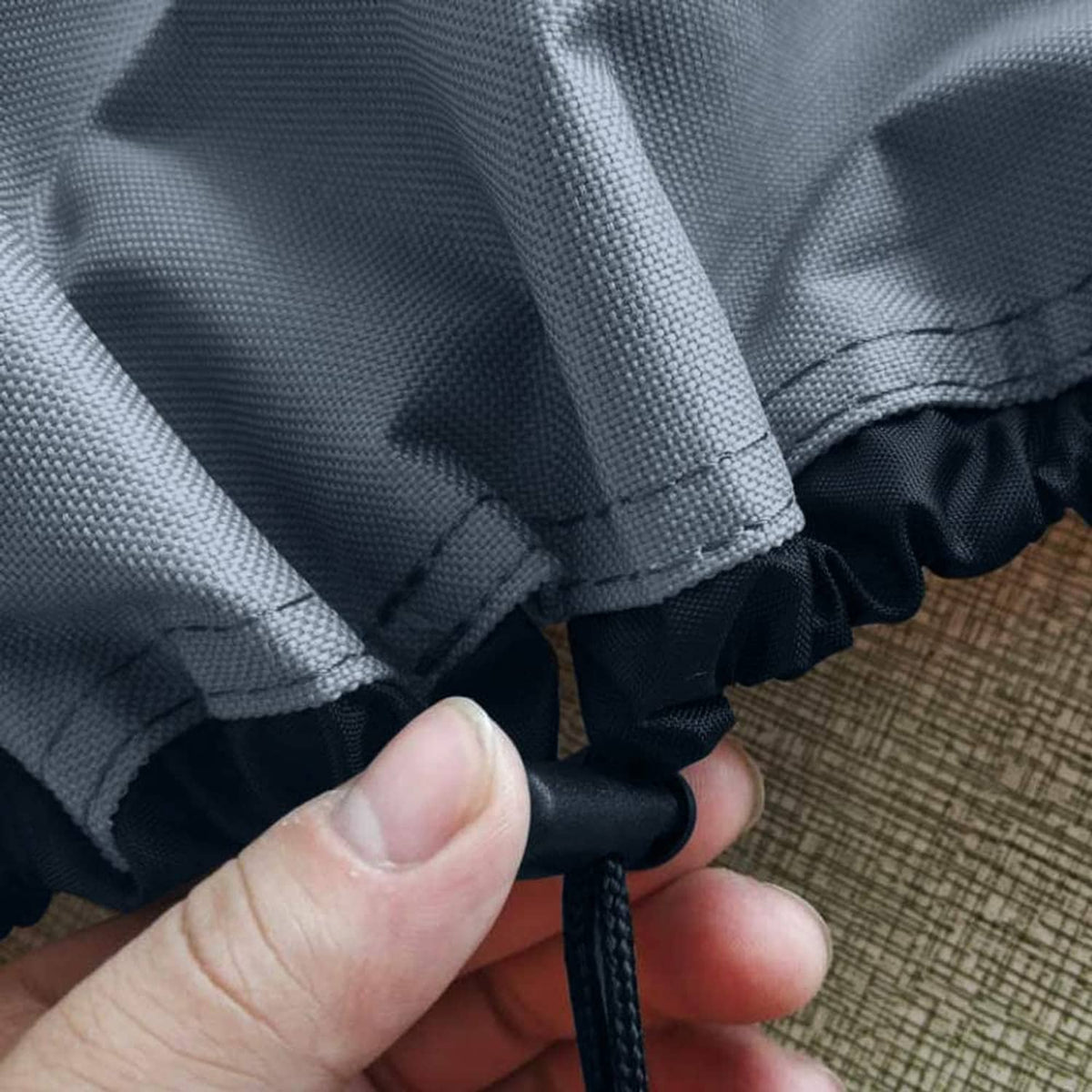 Hot tub cover drawstring tie fastener along dark gray fabric edge
