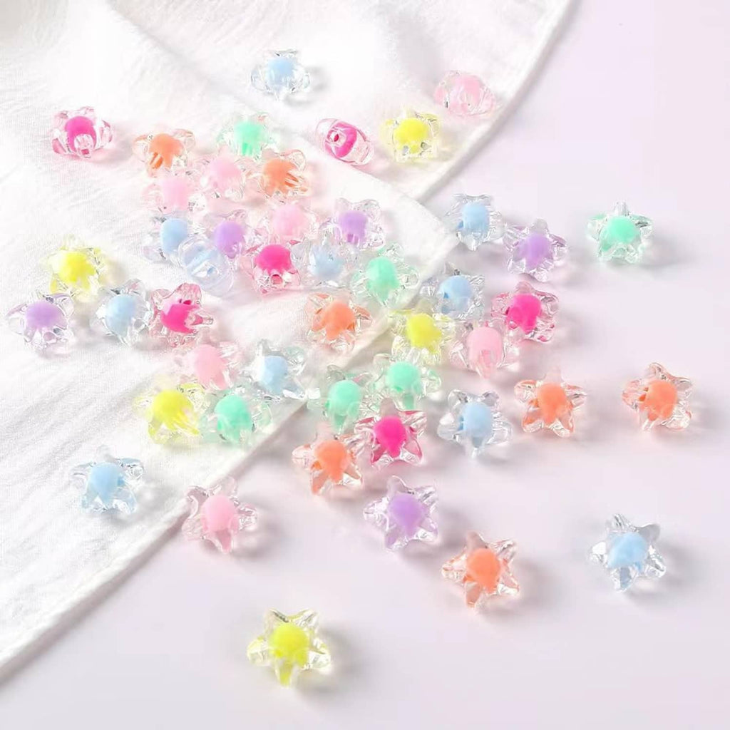 Transparent star beads on white cloth, pastel pink, green, yellow, blue, orange