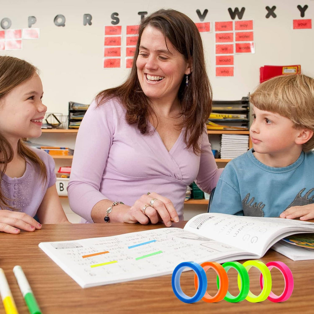 Classroom desk with colorful transparent highlighter tape rolls—blue, green, orange, pink