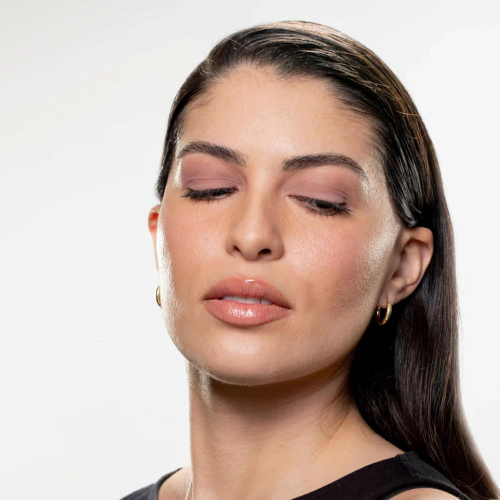 Rose-toned matte eyeshadow look on face, styled brows and smooth skin.
