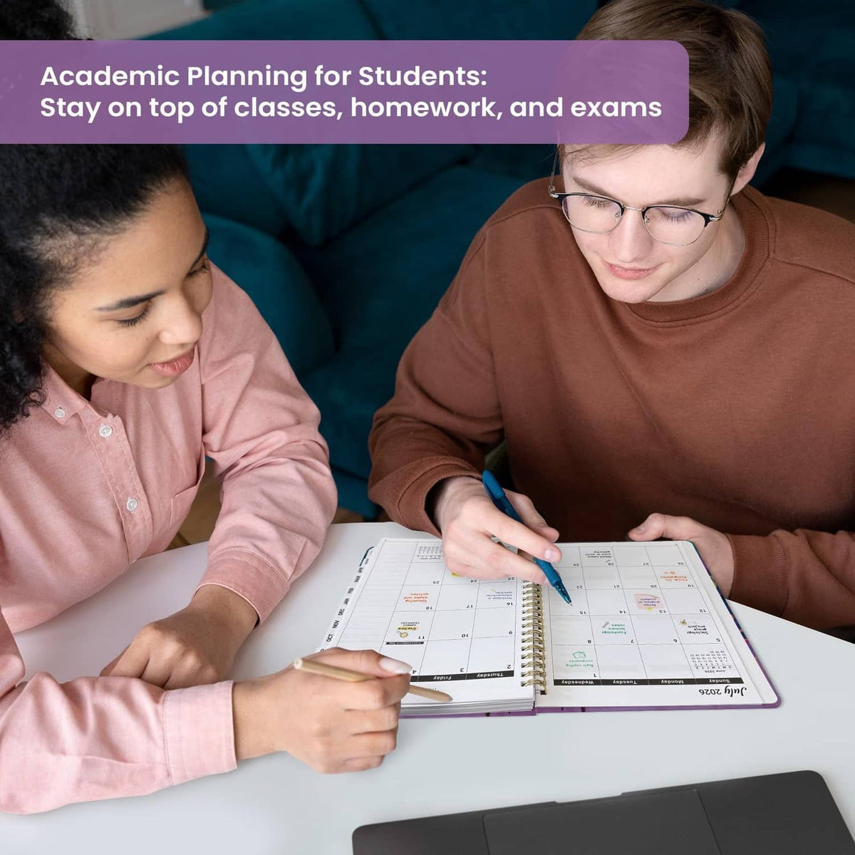 Students writing in an academic planner on a table during study time