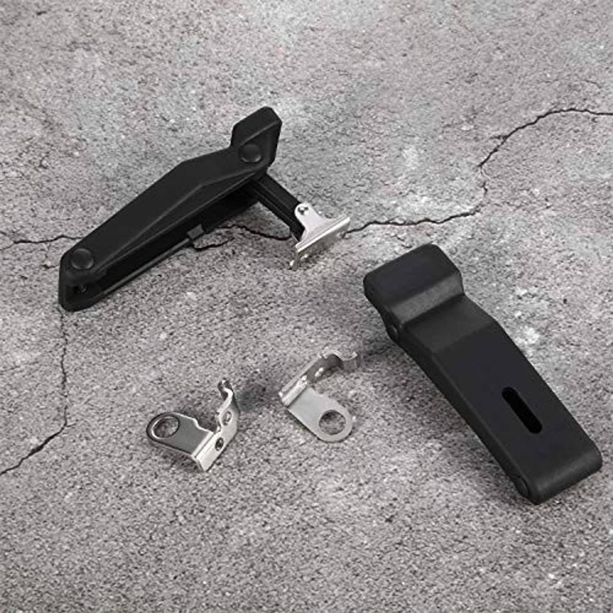 Black rubber latch pieces with metal clips and fasteners, laid out for mounting