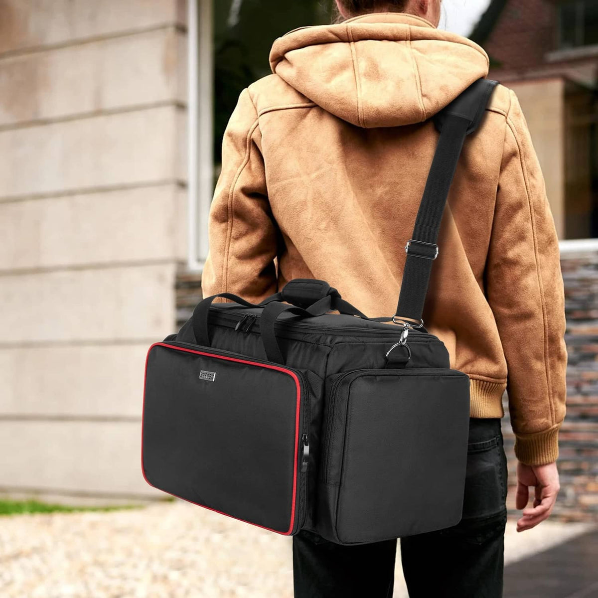 Black hairdresser tool bag with red trim, carried on shoulder strap