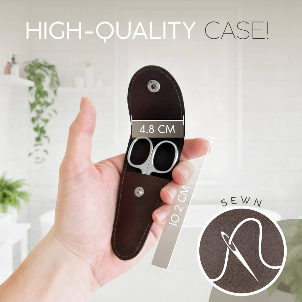 Brown leather case with Solingen nail scissors held in a hand, silver curved blades