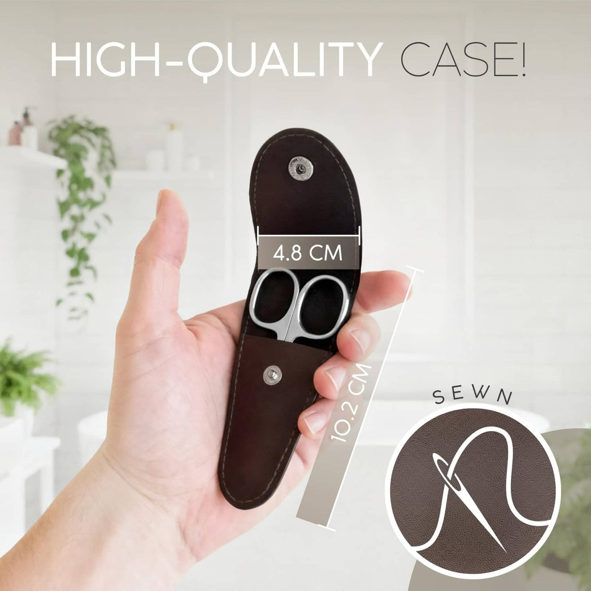 Brown leather case with Solingen nail scissors held in a hand, silver curved blades
