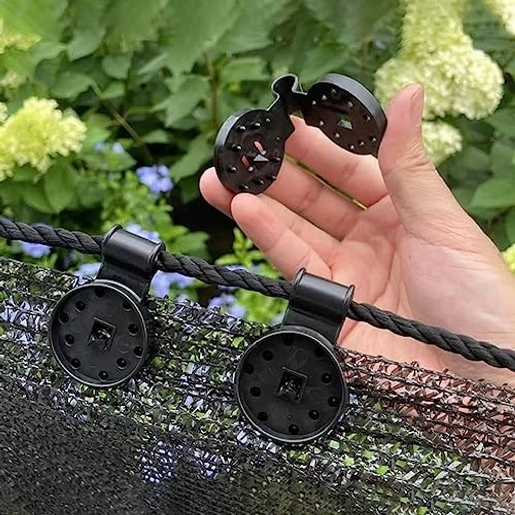 Black shade cloth clips secured to fence netting; hand shows the fastener