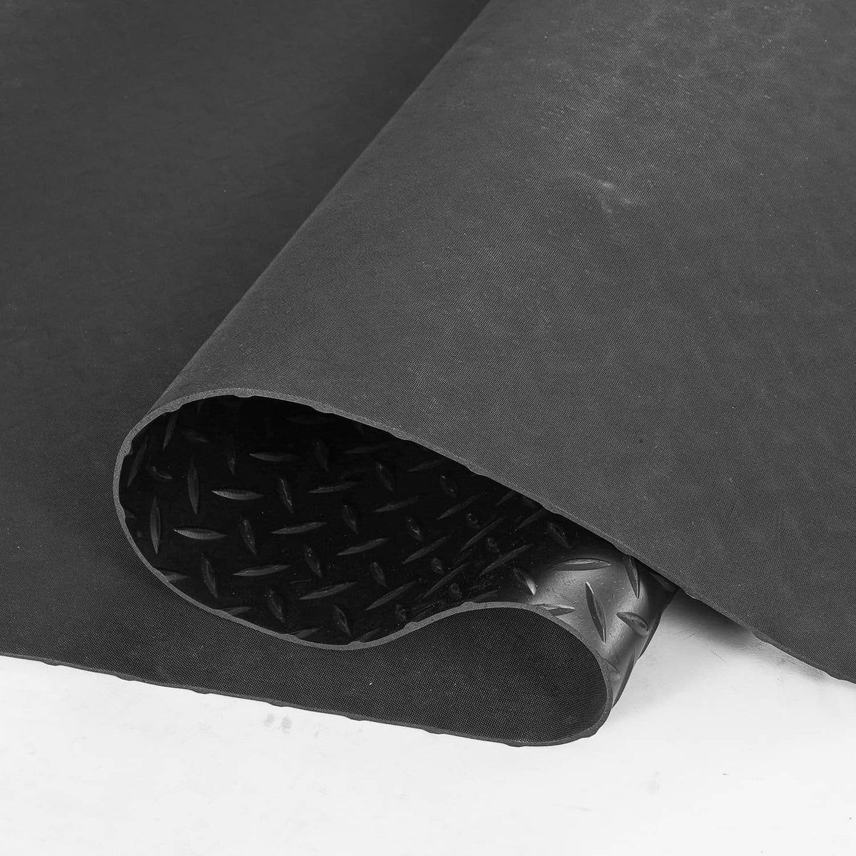 Rolled garage floor mat edge, dark PVC vinyl diamond-plate with textured non-slip
