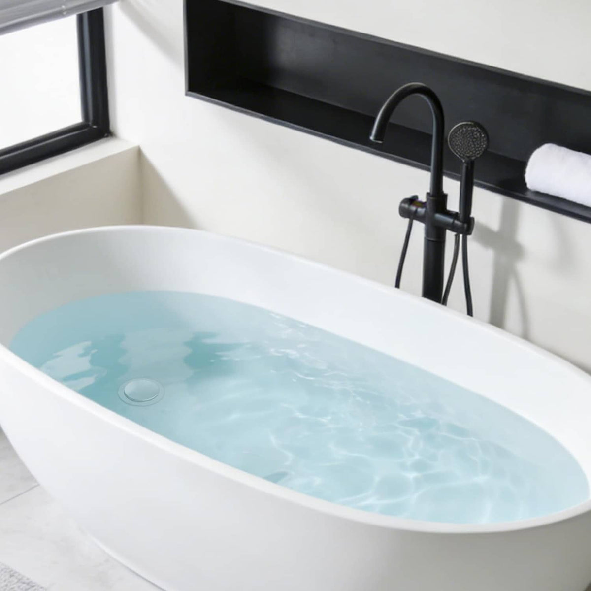 Bathtub with drain area and pop-up stopper near the faucet