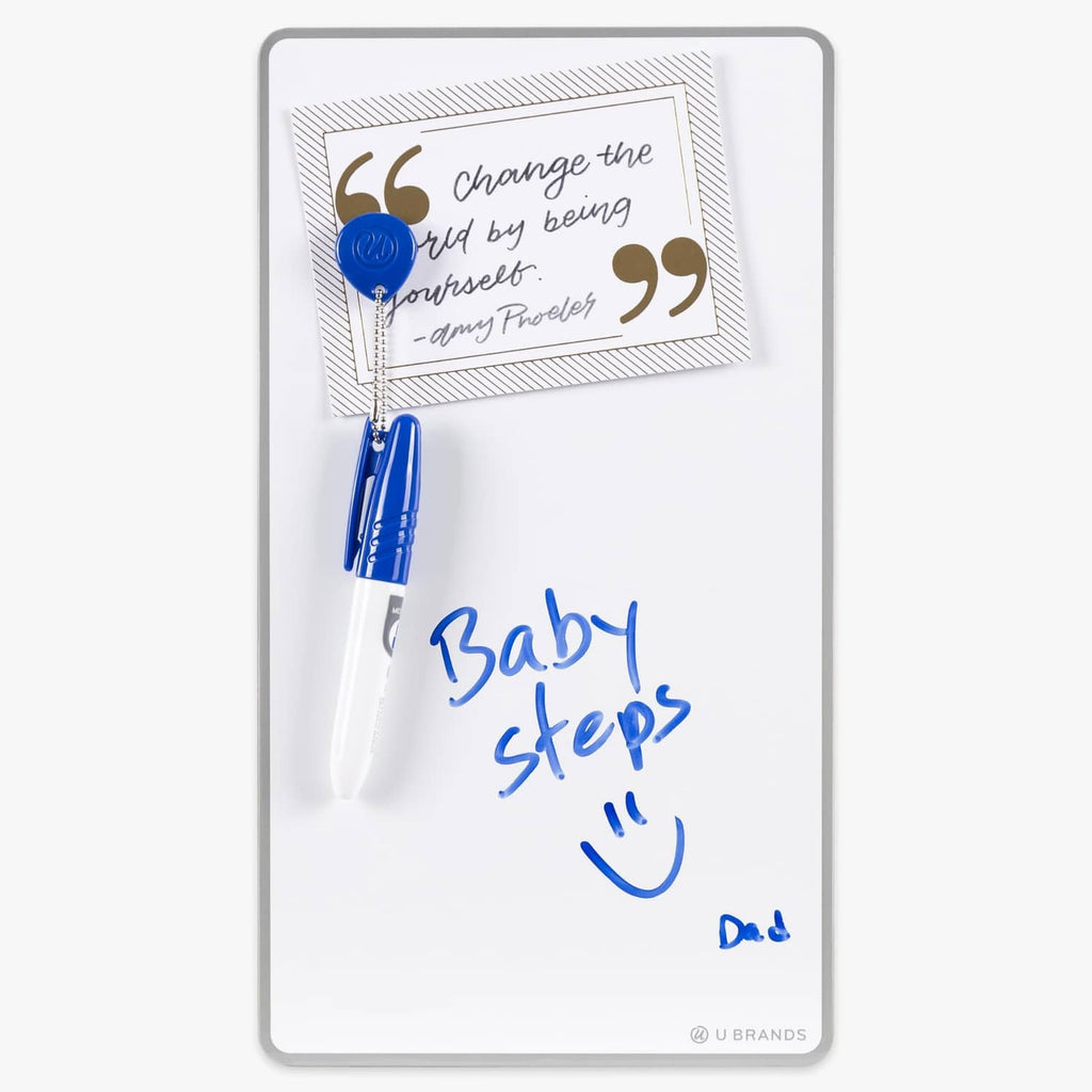 White magnetic dry erase board with blue marker and magnet-held notes