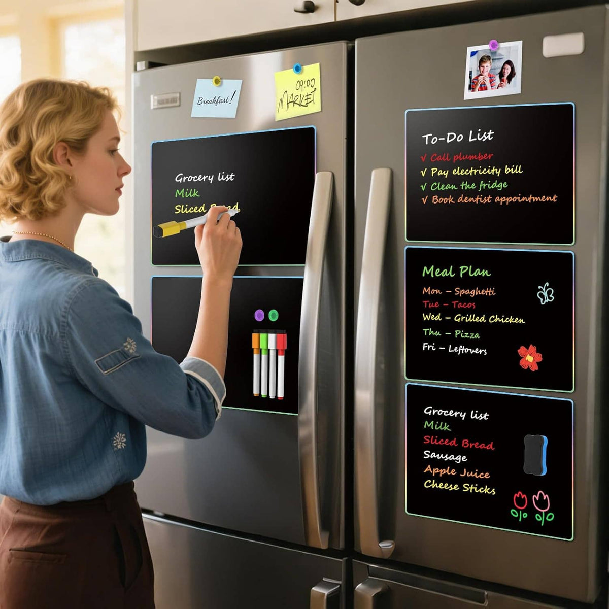 Person writing on multiple magnetic dry erase boards mounted on a refrigerator