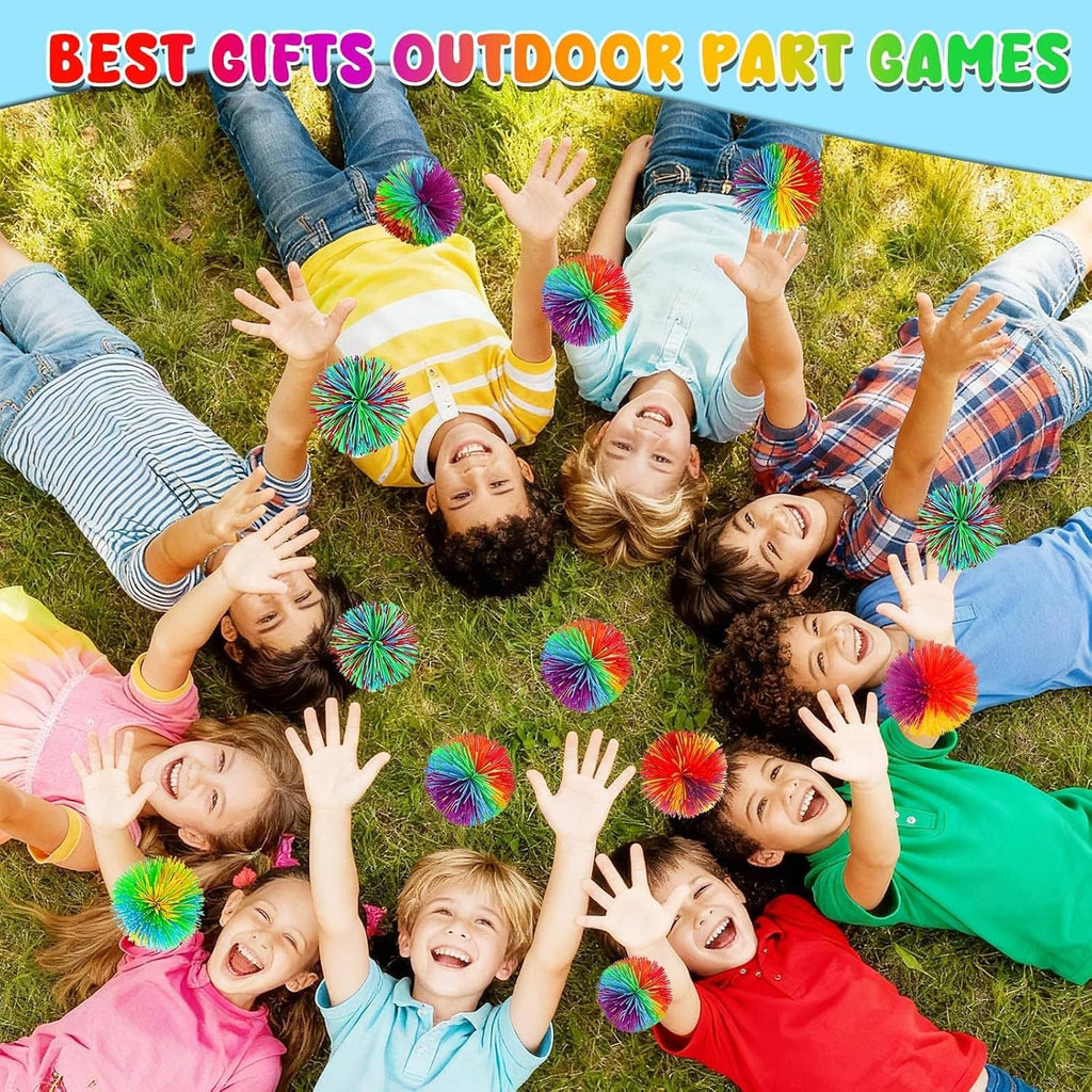 Rainbow stringy pom stress balls in use outdoors on a grass lawn