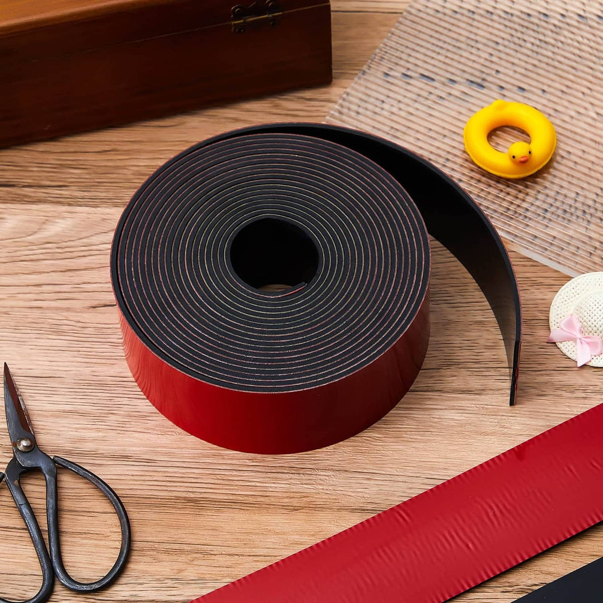 Self-adhesive kayak keel guard roll on wood with matching red-and-black strip