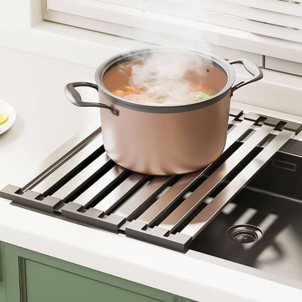 Dish drying rack with black slats supporting a large pot on the sink