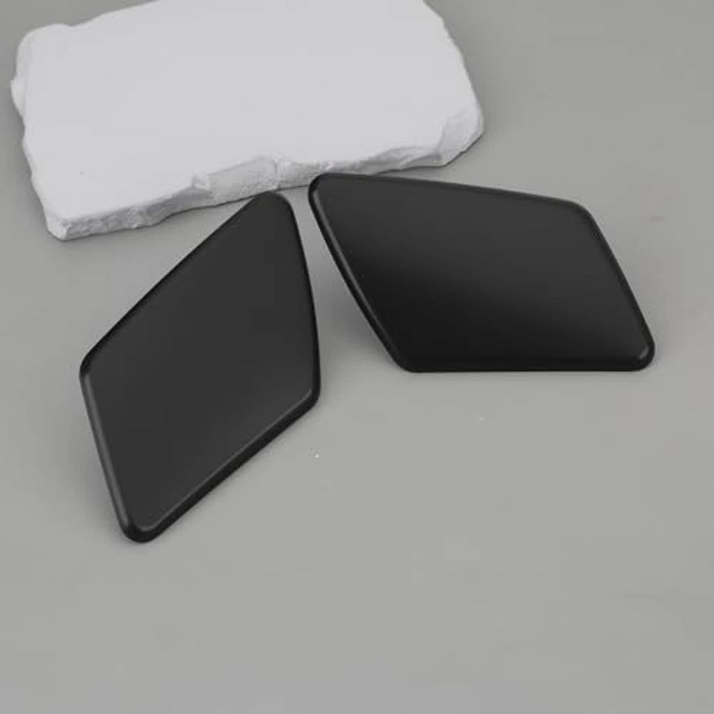 Pair of matte black headlight washer nozzle cover caps, left and right, laid out