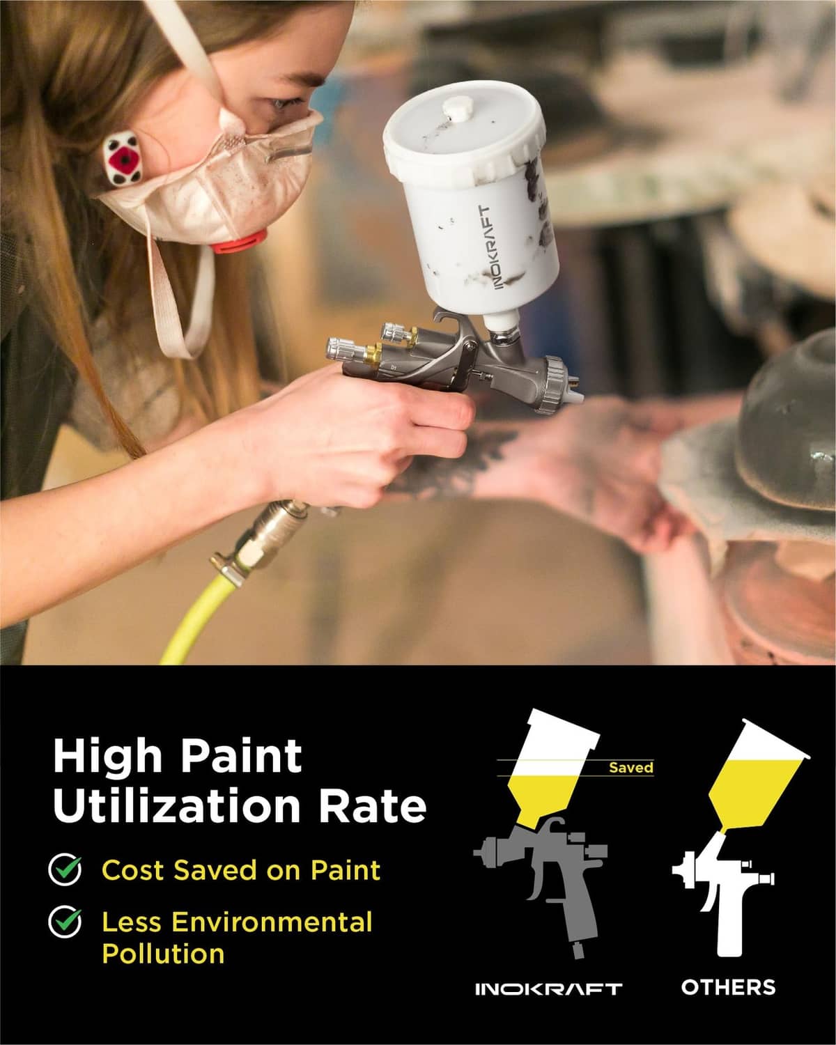 Air spray gun with white paint cup and metal nozzle held during painting