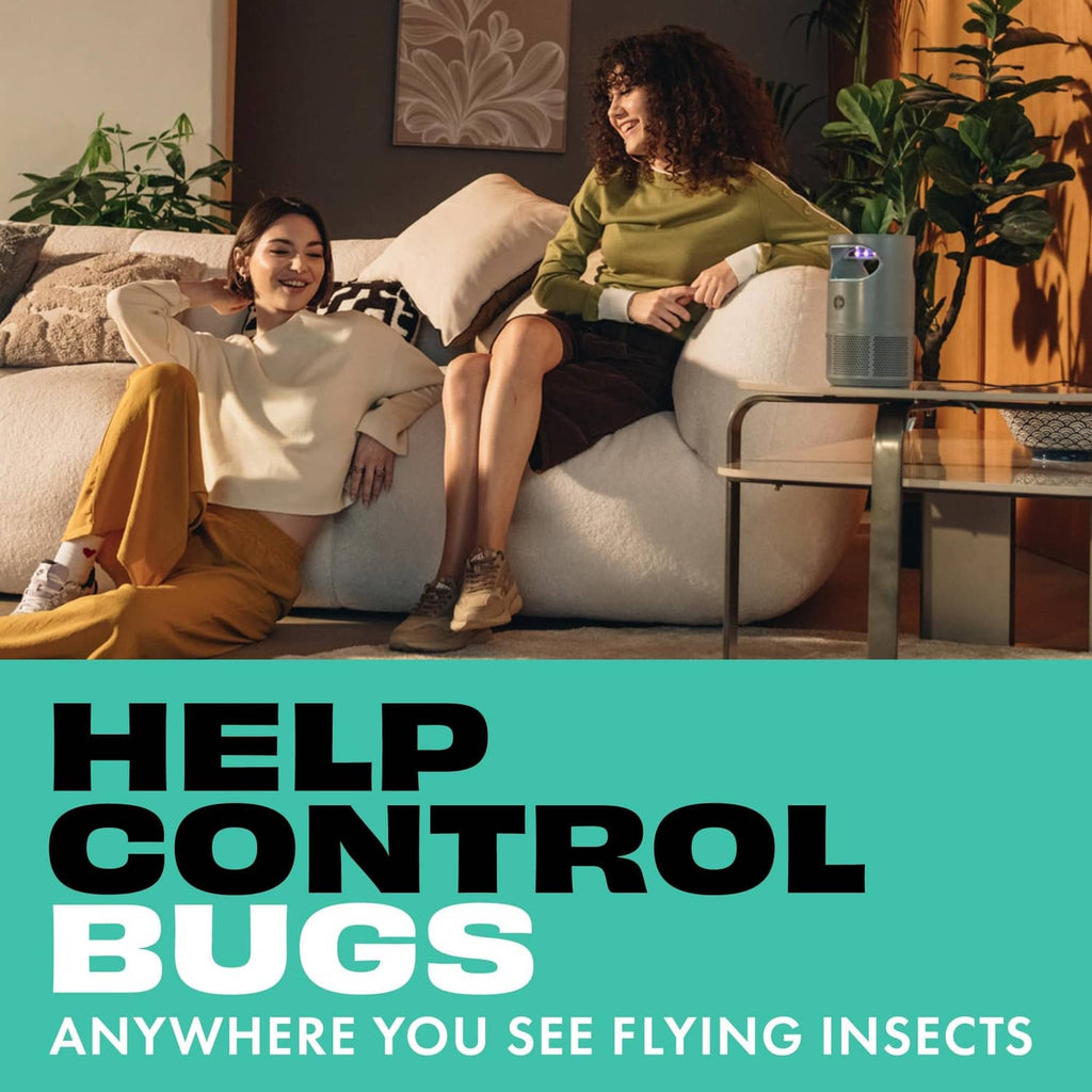 Flying insect fan trap device on table next to a seated person and dog
