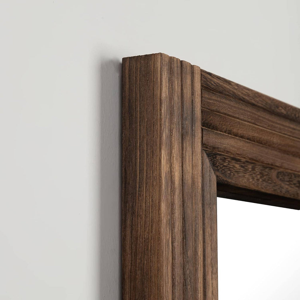 Close-up of rustic spliced wooden mirror frame corner with visible grain texture.