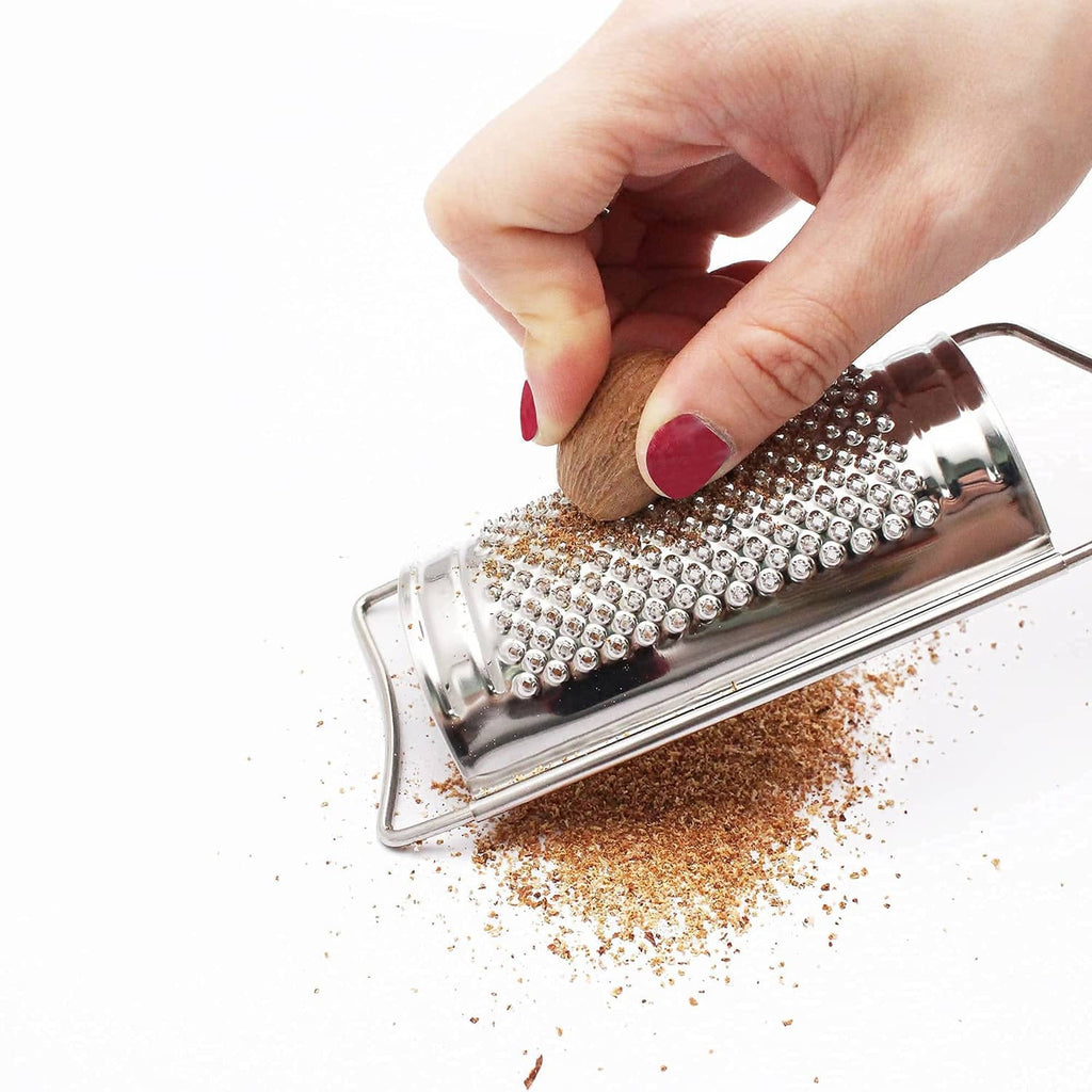 Hand uses a stainless steel grater with box face over grated crumbs