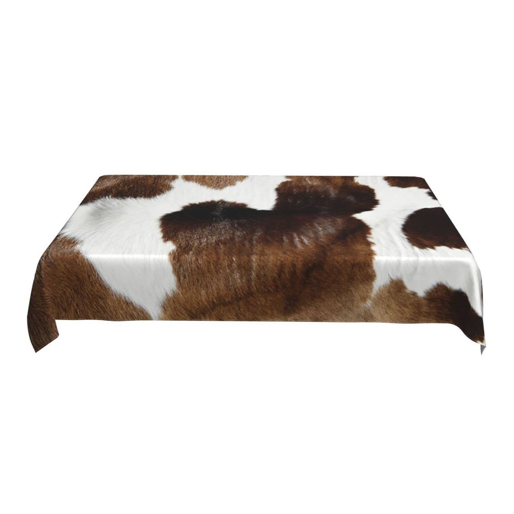 Rectangular cow print tablecloth with brown and white hide pattern, draped corners