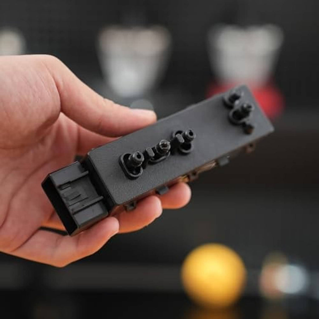 Power seat switch module held in hand, showing black 8-way control knobs