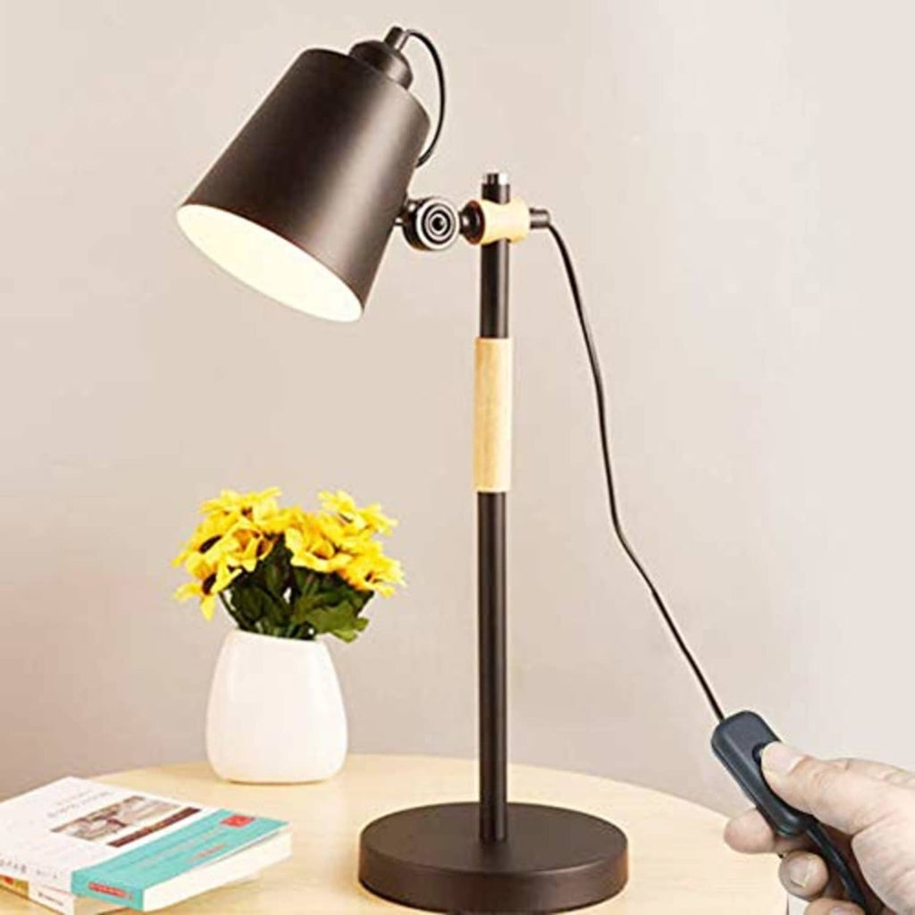 Black inline cord on/off switch attached to a lamp cord, hand pressing button
