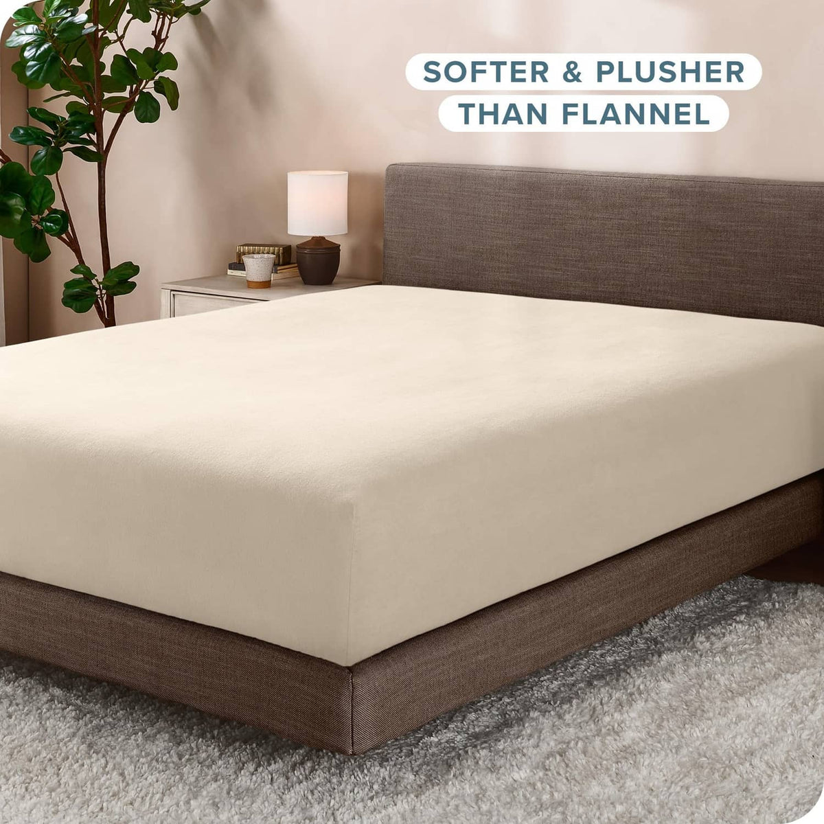 Cream fitted fleece bottom sheet on bed with snug, smooth fit and neat corners.