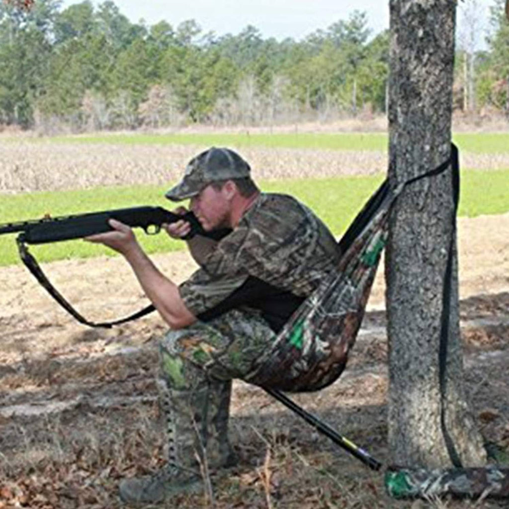 Camouflage hammock-style camping chair with black straps hanging from a tree