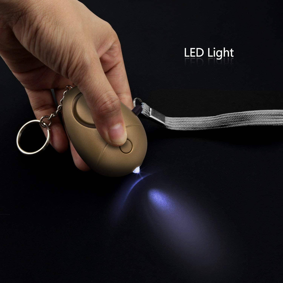 Tan personal security alarm keychain with LED light, key ring, and pull cord.