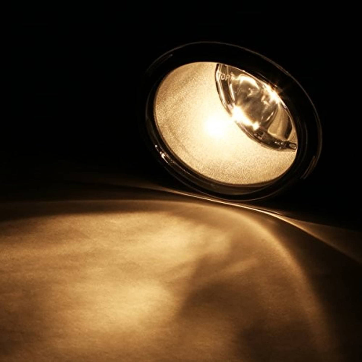 Amber front fog light glowing through clear lens with chrome reflector