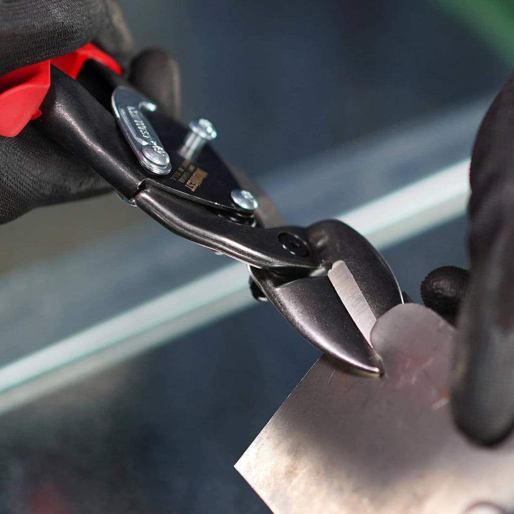 Close-up of offset aviation snip jaws gripping a sheet of metal
