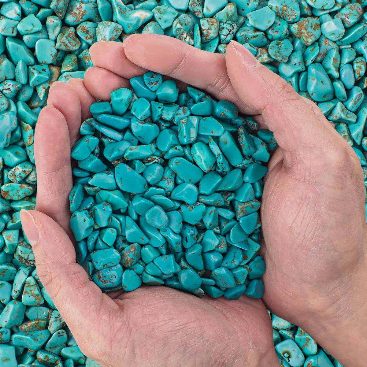 Turquoise howlite crystal chips in a handful, small tumbled crushed stones bulk pieces