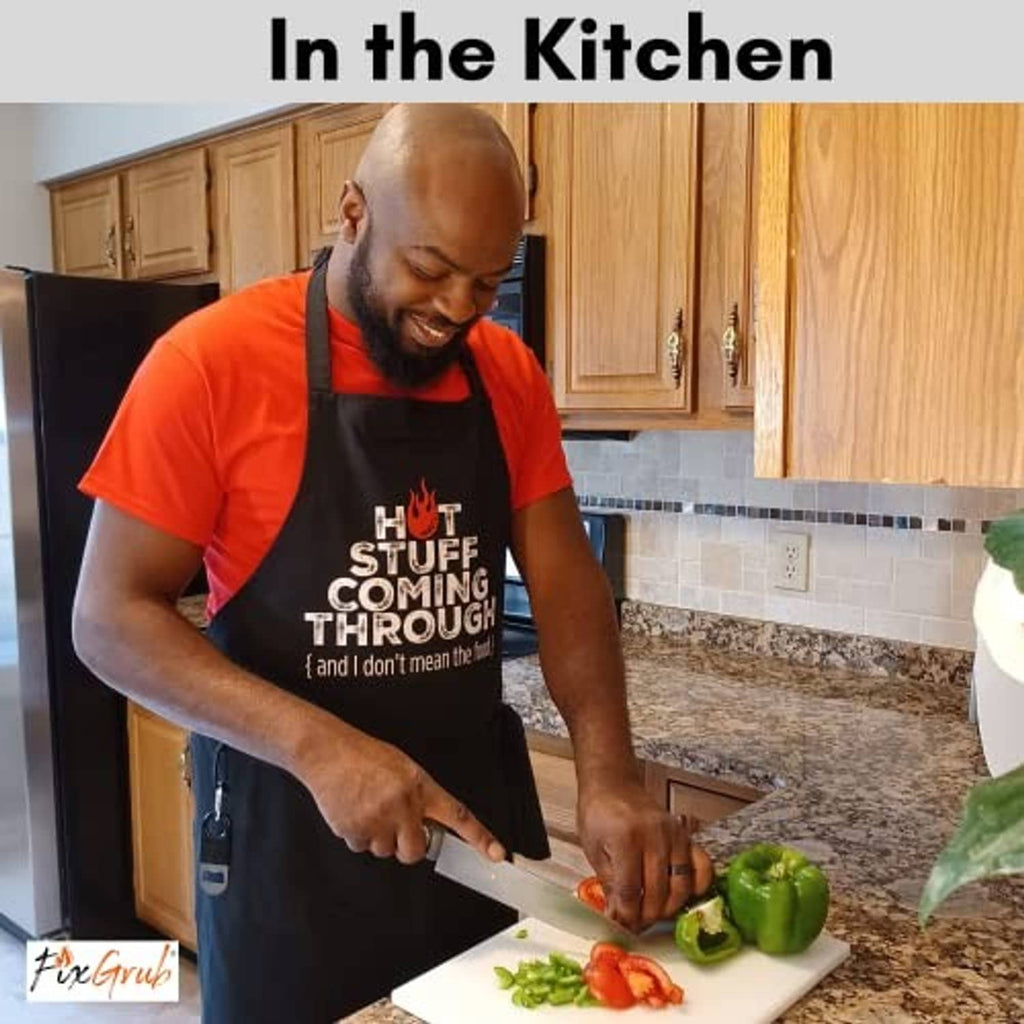Black chef apron with “Hot Stuff Coming Through” slogan worn while cooking