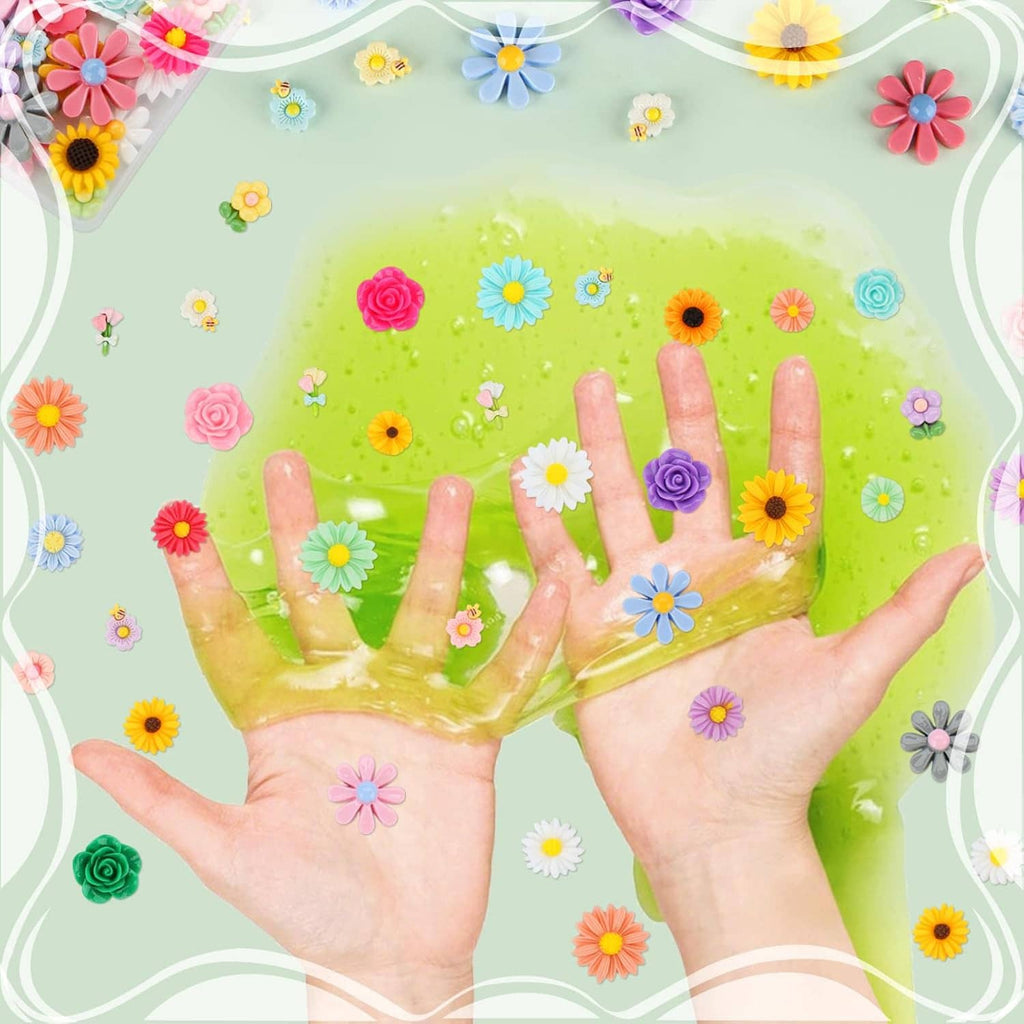 Mini resin flowers scattered across two hands, colorful flatback flower pieces