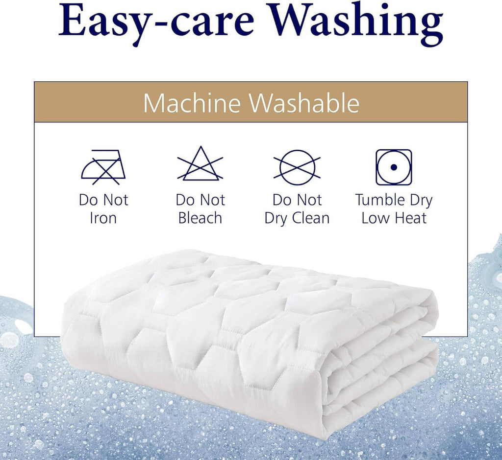 Folded white quilted mattress pad with machine-wash care icons