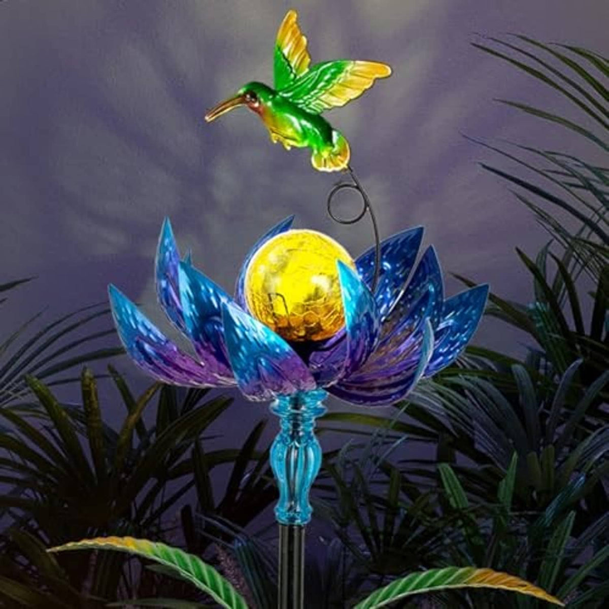 Solar wind spinner with green hummingbird and blue-purple flower petals around a glowing orb