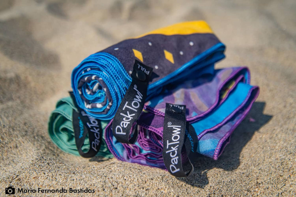 Rolled PackTowl ultralight body towels with Desert Aire print, blue and purple.