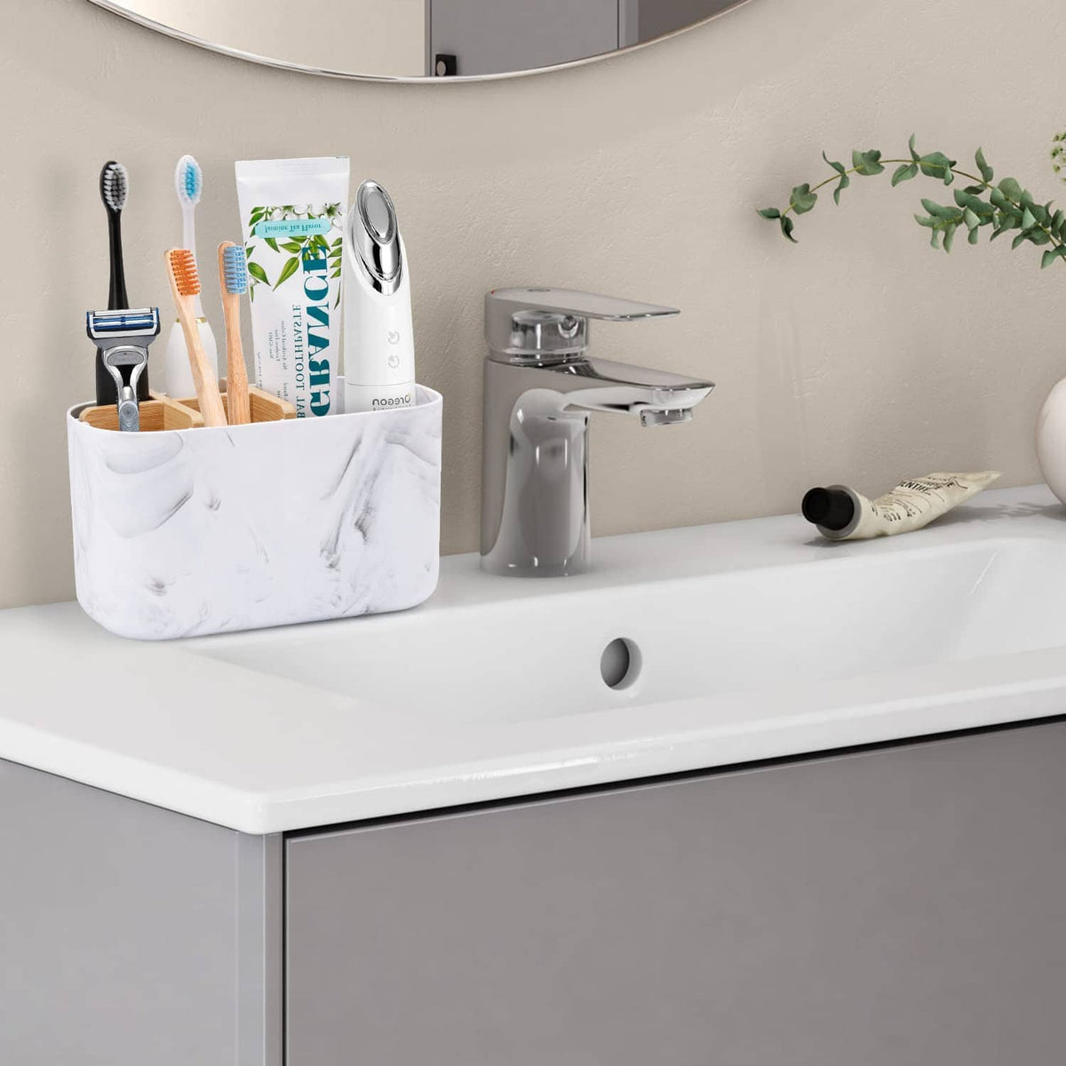 Marble-look 5-slot bamboo toothbrush holder on bathroom counter with toothbrushes in slots