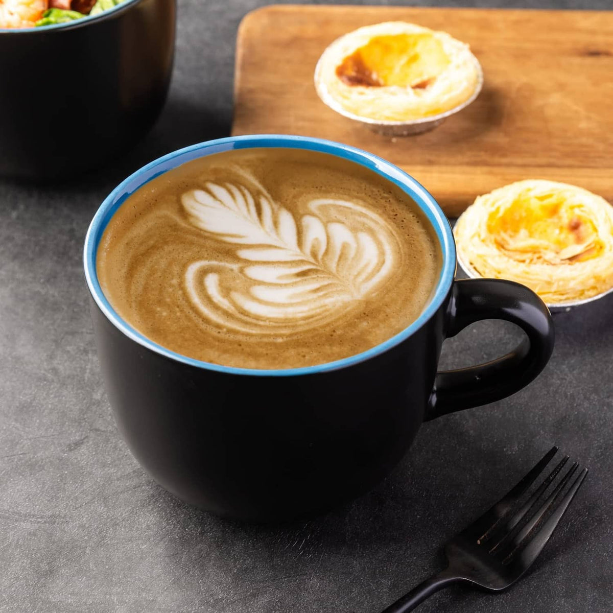 Black soup mug with handle, filled with creamy soup and latte-style foam