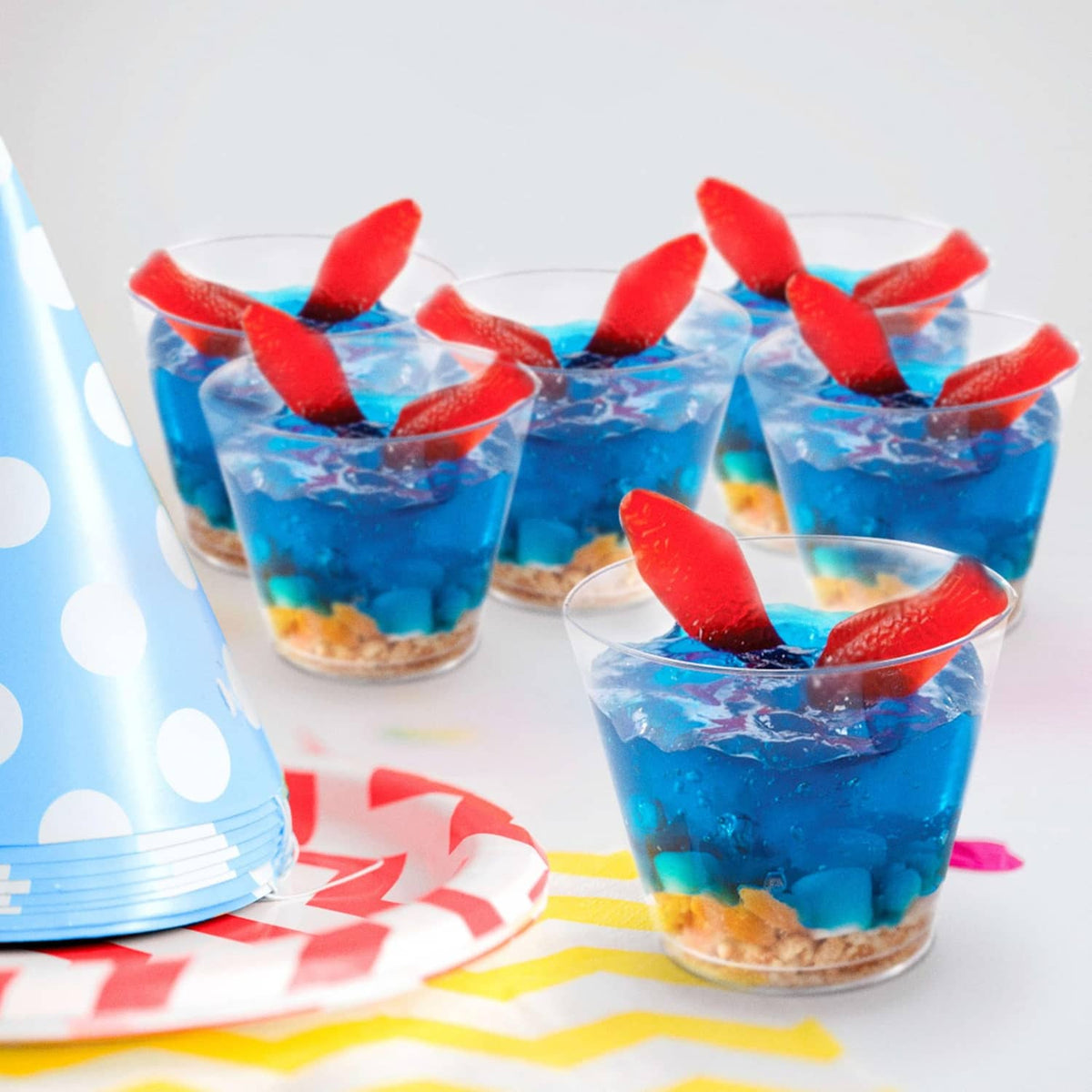 Red gummy fish candy toppers on blue gelatin cups