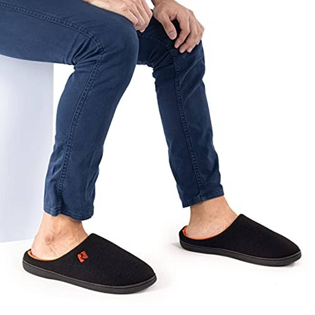 Men's black two-tone memory foam slippers with orange-lined openings, worn
