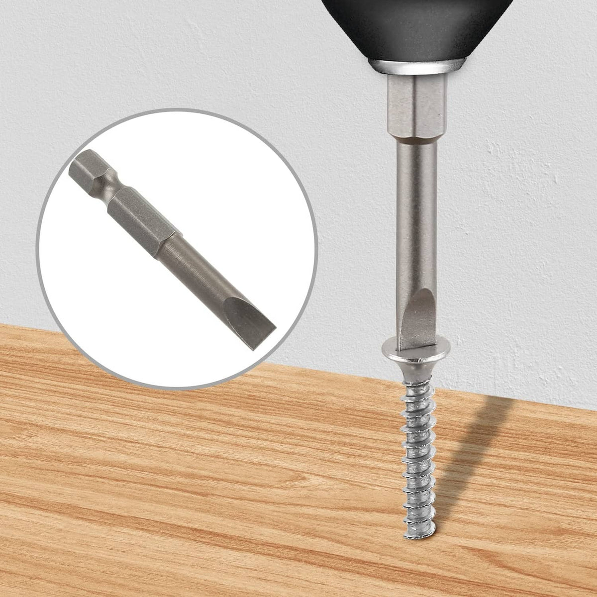 Flat-head slotted bit inserted into a screw on a wooden board