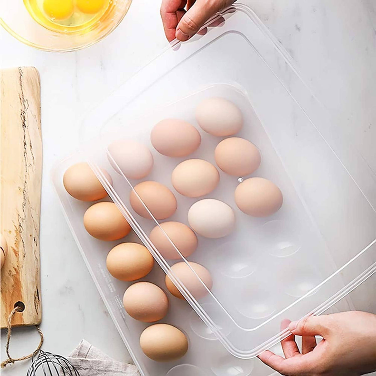 Clear deviled egg tray carrier with lid, hands lifting to reveal egg compartments